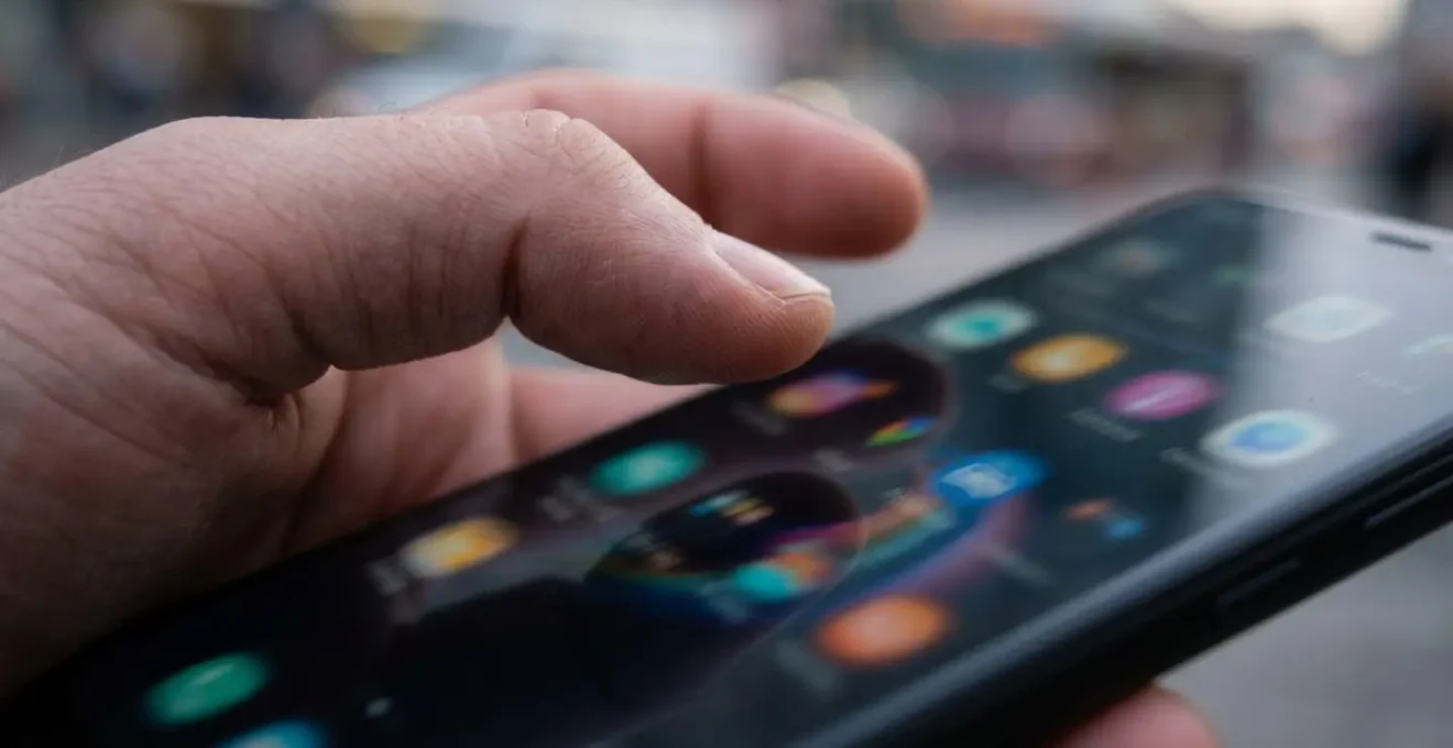 Makroaufnahme von Händen mit Smartphone zeigt verschwommene Optionen, was die Entscheidungslähmung bei zu vielen Wahlmöglichkeiten symbolisiert.